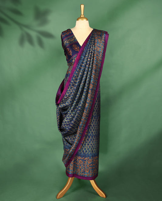 Blue Colour Manipuri saree features a brick patterned body in olive and indigo hues, beautifully offset by a contrasting magenta border with copper floral-printed, and comes with a matching blouse.