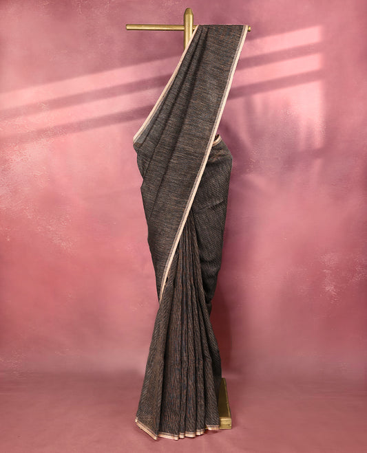Black colour pure linen saree featuring fine beige thread stripes running throughout the body, accented with a soft beige border and pairs gracefully with a matching blouse.
