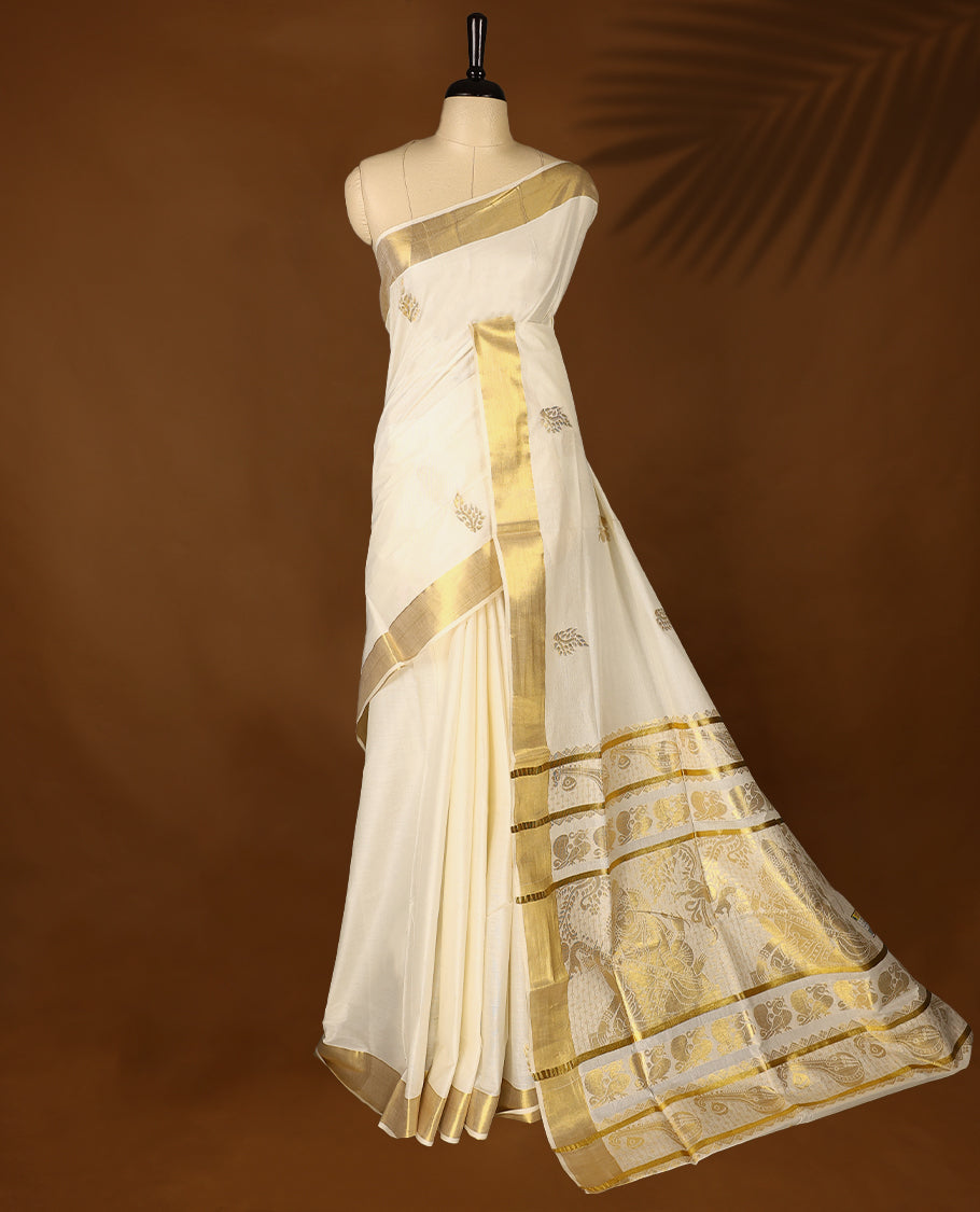 Elegant off white colour cotton Kerala saree featuring Gold zari Floral motifs on body, traditional golden zari kasavu border & Rich Pallu offering a classic and graceful look, paired with a matching blouse.