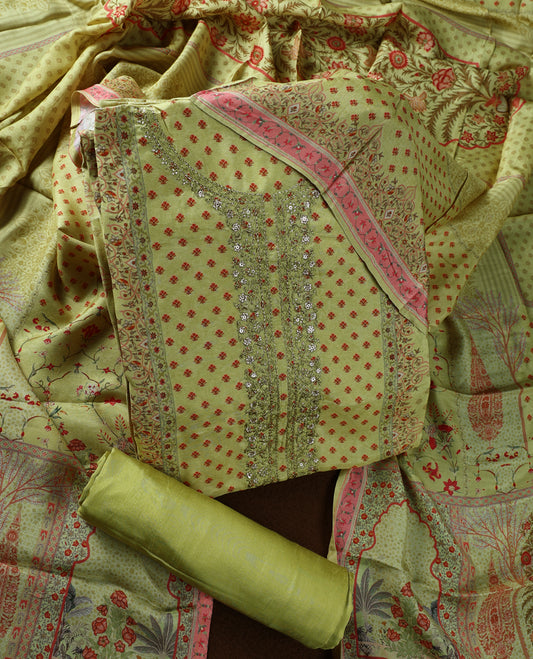 Olive green colour churidhar material adorned with subtle red prints and intricate embroidery on the neckline, paired with a beautifully printed dupatta and plain matching bottom.