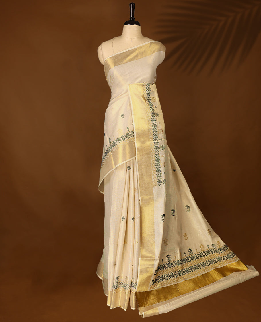 Elegant Light Gold colour Tissue Kerala saree featuring Green & gold geometric pattern embroidery worked body and traditional golden zari kasavu border offering a classic and graceful look, paired with a matching blouse.