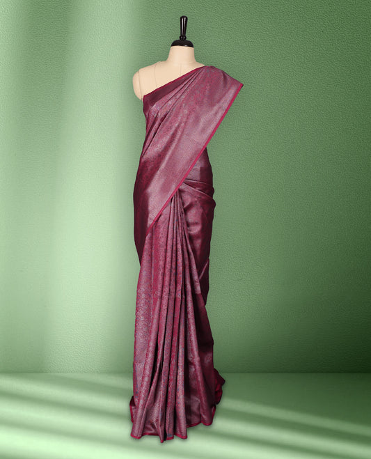 Dark Magenta colour semi silk saree featuring neem zari floral kodi motifs all over the body, complemented by a rich self colour woven border, with matching blouse.