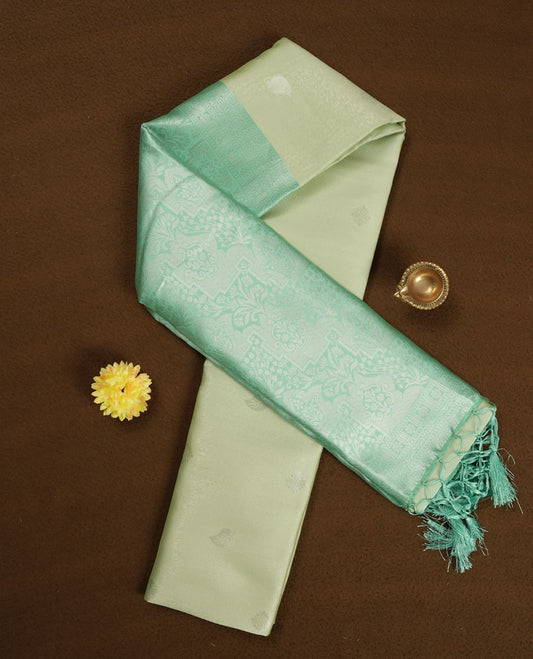 Light green colour semi silk saree adorned with silver leaf motifs on the body, complemented by a aqua green pallu intricately woven with rich floral patterns border and pallu, and paired with a matching blouse