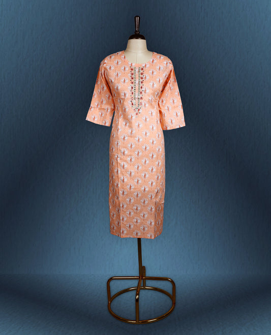 Peach colour kurti with all over white floral prints, featuring a round neckline adorned with vertical thread and mirror embroidery, and three quarter sleeves