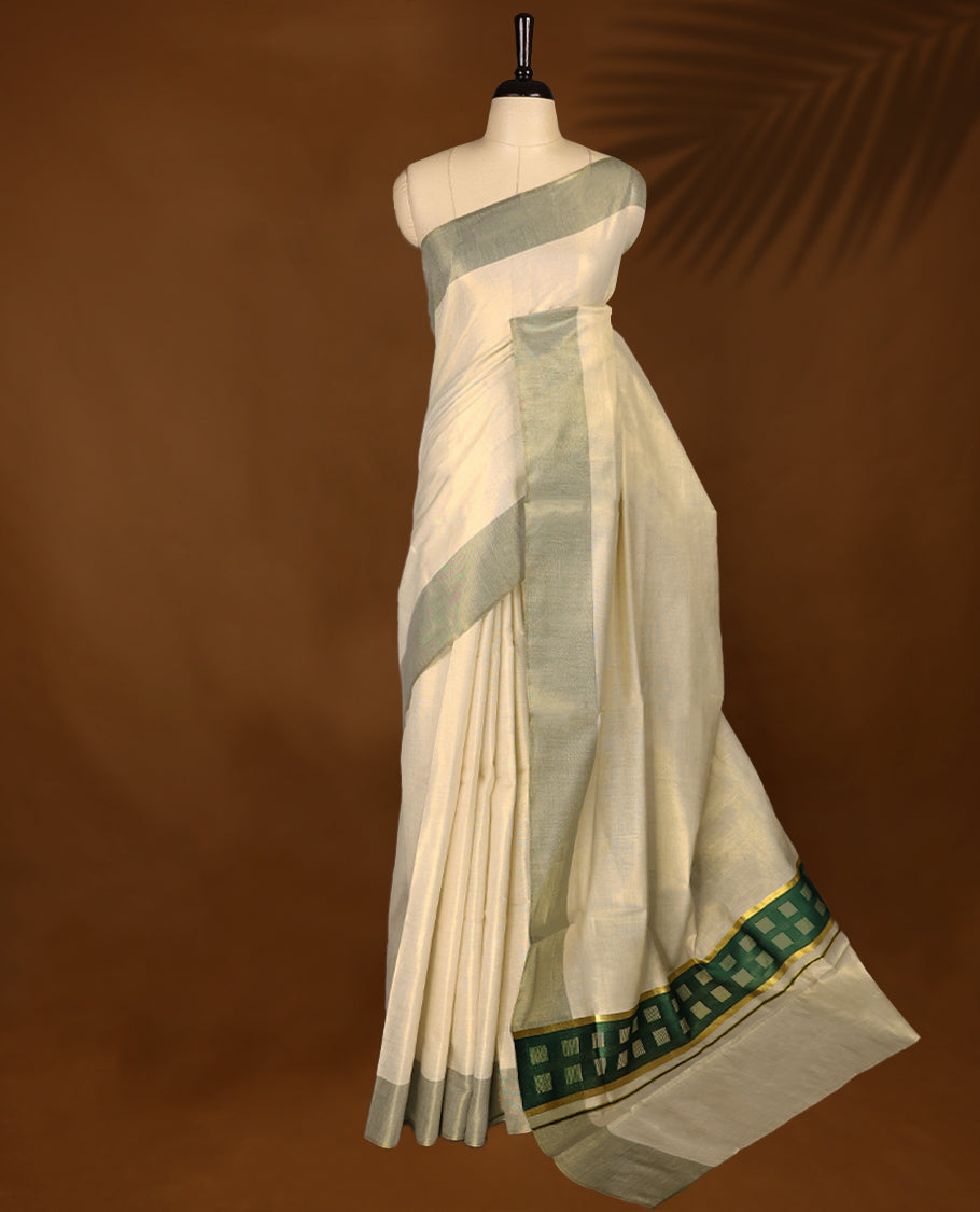 Elegant light gold Colour soft tissue Kerala saree featuring a plain body, muted green zari border, and a striking green woven checkered pallu, paired with a matching blouse.