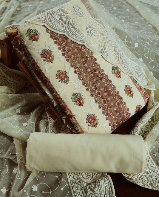 Cream and Peach churidhar material with floral thread & sequin embroidery, paired with a soft plain bottom & Comes with a sheer embroidered dupatta with fine lace borders & floral motifs for an elegant, graceful look.