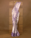 Pastel lavender Colour Kancheepuram tissue silk saree embellished with intricate silver zari work on the body, elegantly enhanced by a lavender traditional Chakkram and floral kodi design border, and paired with a matching blouse.