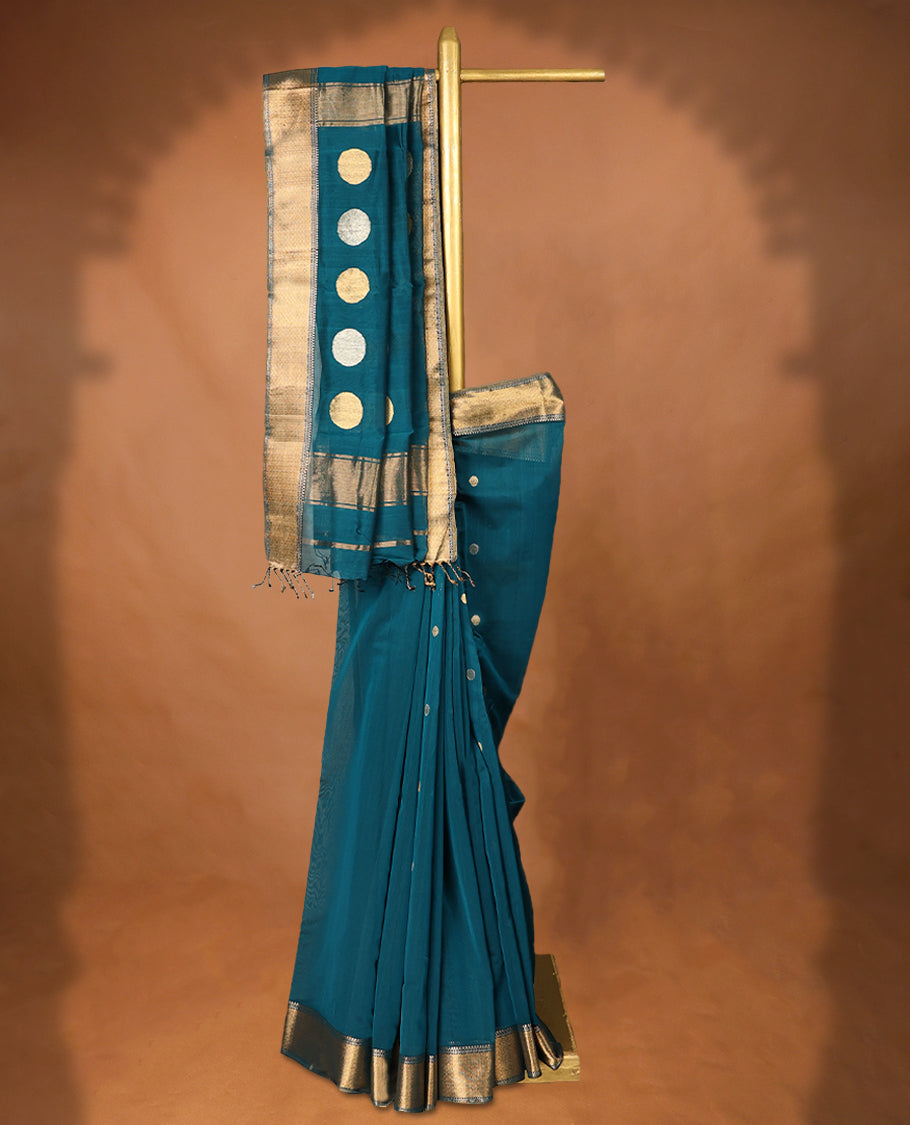 Peacock Blue colour Maheshwari Cotton saree featuring Antique Zari bindi Patterns across the entire body, complemented by a traditional Gold Zari border & Pallu, with a matching blouse.