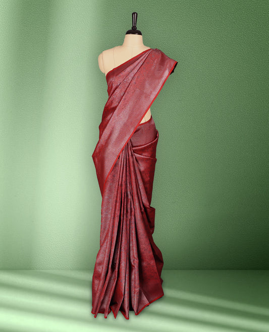Red colour semi silk saree featuring neem zari floral kodi motifs all over the body, complemented by a rich self colour woven border, with matching blouse.
