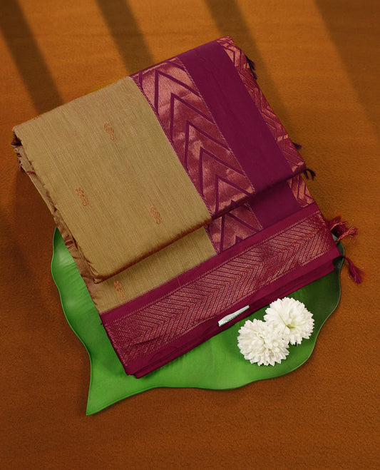 Sand yellow and Maroon Kalyani cotton saree featuring small woven motifs on the body, highlighted with rich zigzag and geometric zari patterns on the border and pallu, paired with a matching blouse.