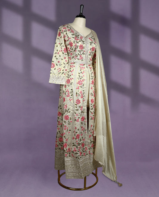 Off white colour kurti set is beautifully adorned with floral embroidery in pink and green tones, The elegant top features a V neckline and three quarter sleeves, complemented by a matching dupatta and bottom.