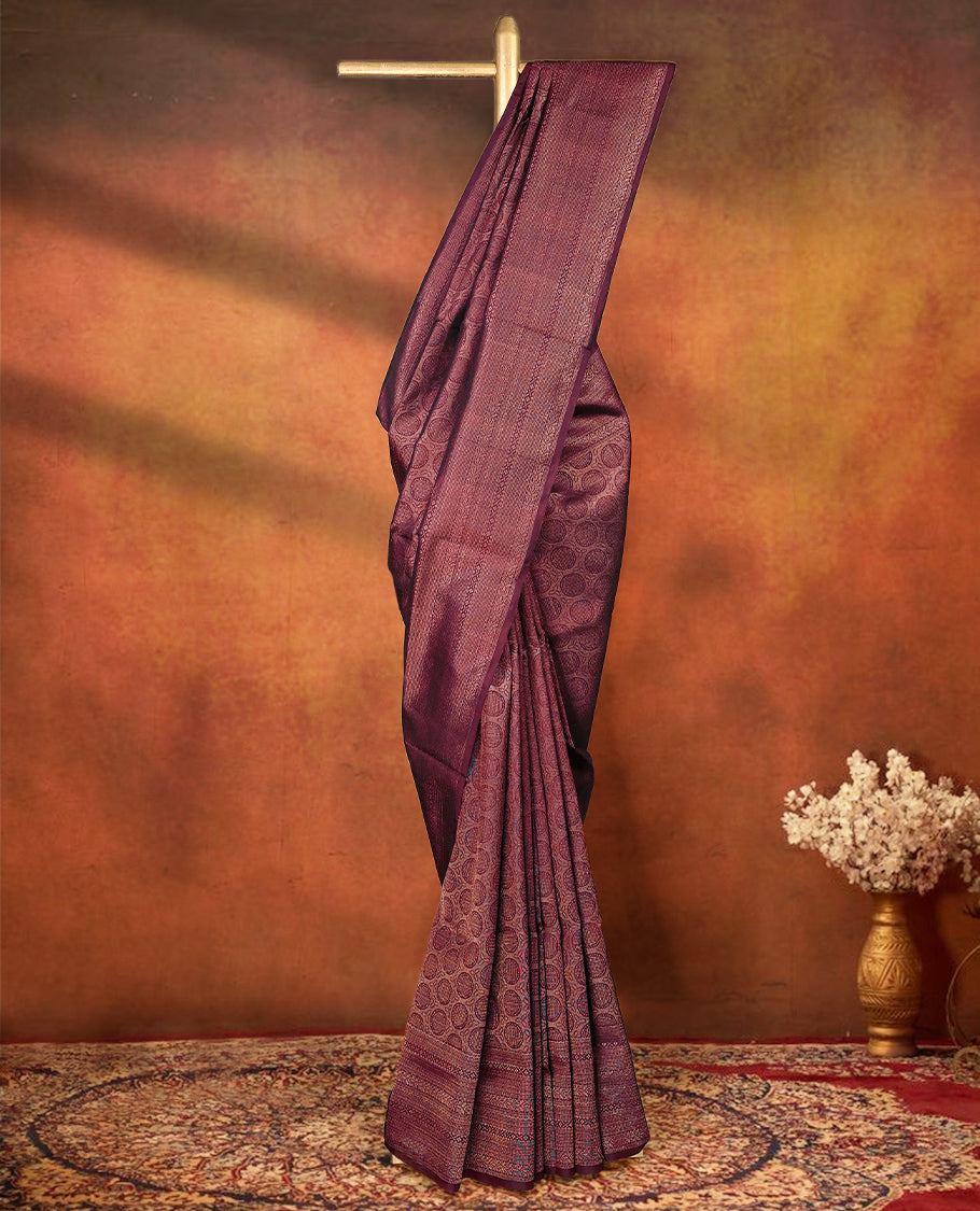 Deep Maroon colour pure Mayuri silk saree featuring finely woven Golden zari motifs across the body, detailed with a subtle geometric self border with intricate texture, with matching blouse