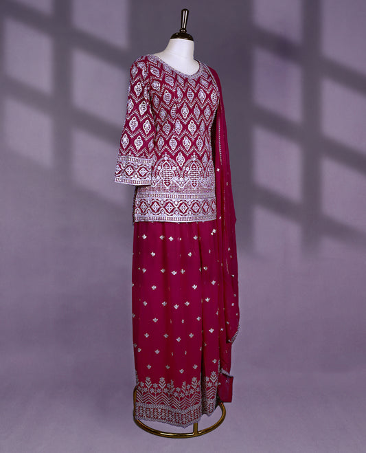 Rich maroon colour sharara set featuring a V neckline, three quarter sleeves, intricate white thread embroidery, a matching flared bottom, and a beautifully adorned dupatta