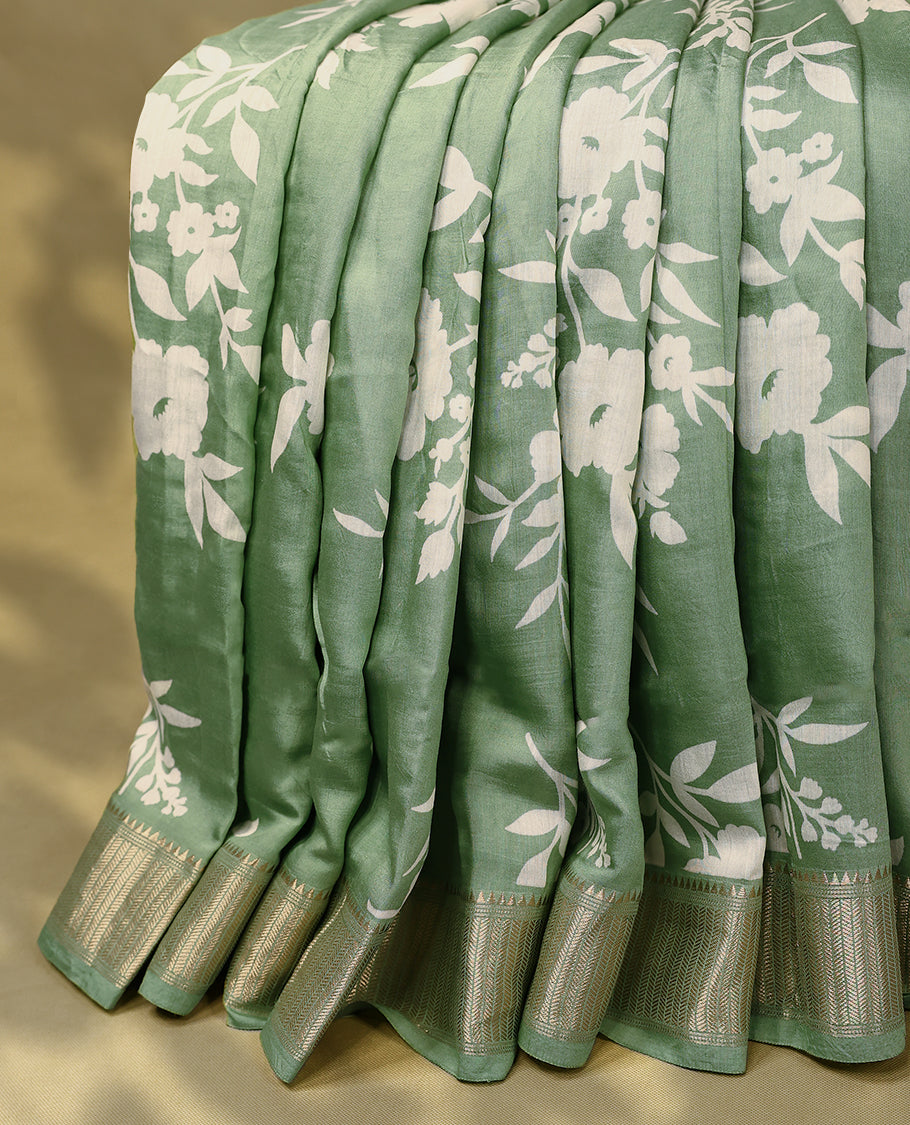 Soft sage green colour Viscos semi printed saree featuring a golden zari border, white floral printed motifs on the body, and comes with a matching blouse