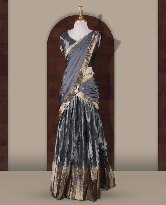 Gray colour Dhavani set featuring a Gray colour skirt with contrast Gold colour border with rich gold zari pattern, paired with a Matching dupatta detailed with Gold motifs.