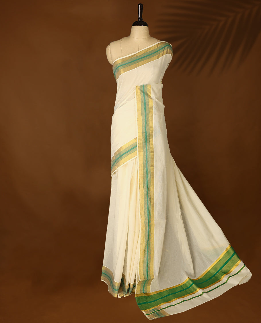 Elegant off white colour cotton Kerala saree featuring Plain body, Green colour & golden zari kasavu border offering a classic and graceful look, paired with a matching blouse.