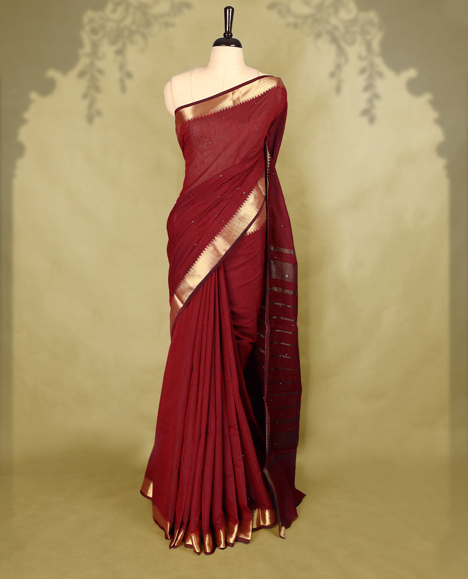 Maroon colour Chanderi cotton saree featuring a subtly textured body with delicate buti work, complemented by a rich golden zari border with matching blouse