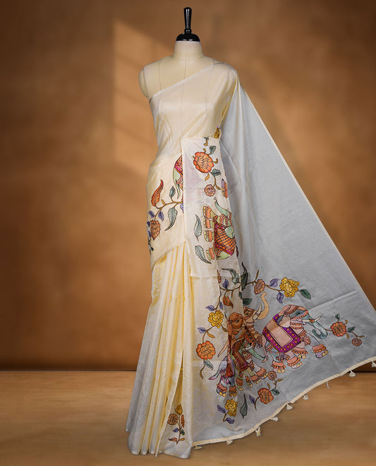 Cream off-white semi tusser silk saree featuring artistic floral and elephant motifs on the pallu with subtle contrast detailing along the border, paired with a matching printed blouse.