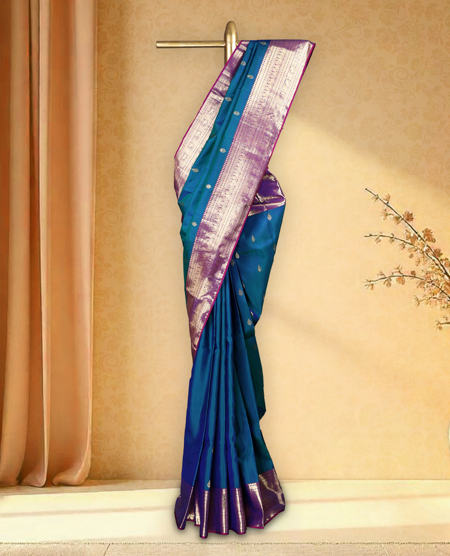Peacock blue colour pure Kancheepuram saree with gold zari traditional paisley motifs on the body contrast traditional border with peacock, winged horse and chackram motifs grand pallu with diamond pattern paired with matching blouse
