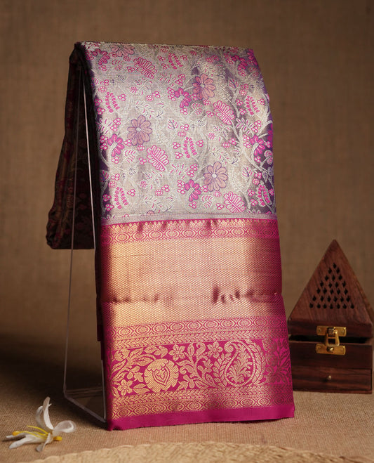Pastel lavender colour and Antique silver Zari Tissue Brocade Saree features intricate coloured floral Motifs on body and bright pink colour border & pallu with traditional patterns, paired with matching blouse