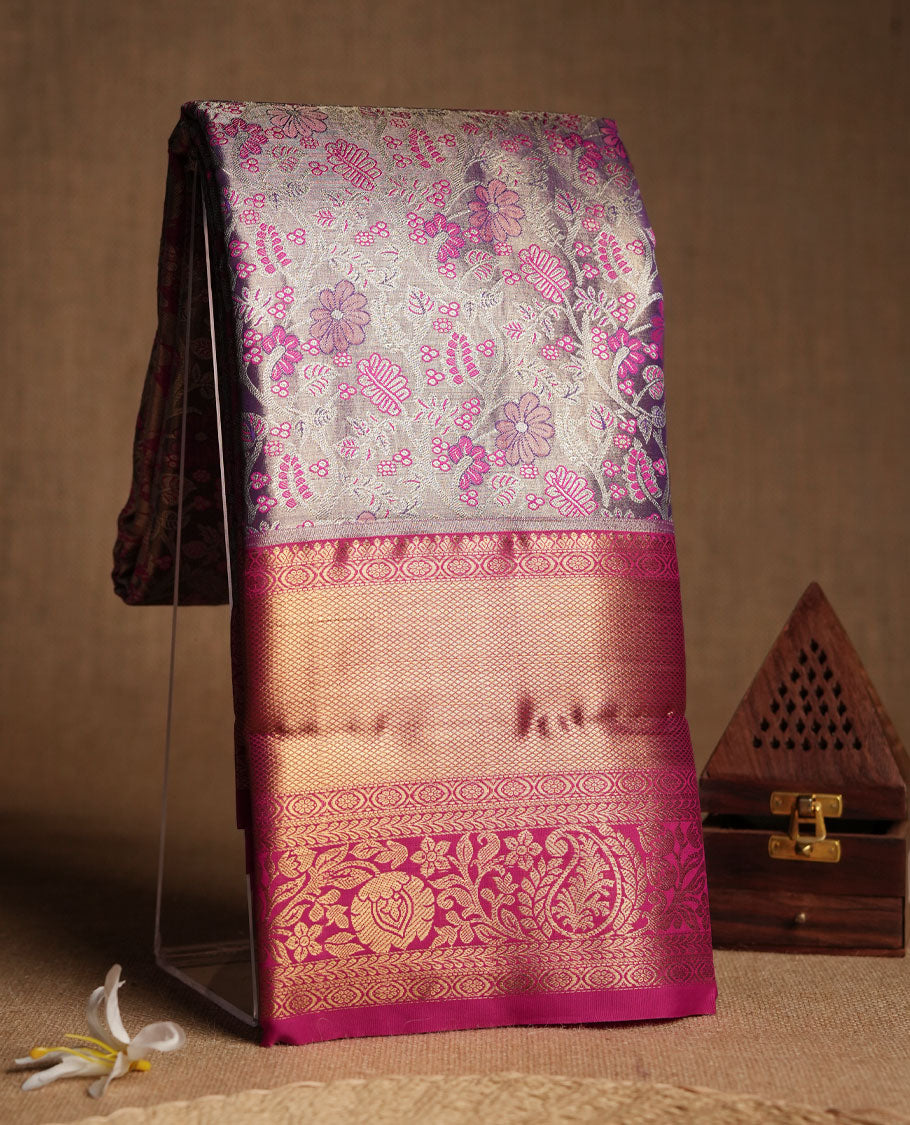 Pastel lavender colour and Antique silver Zari Tissue Brocade Saree features intricate coloured floral Motifs on body and bright pink colour border & pallu with traditional patterns, paired with matching blouse