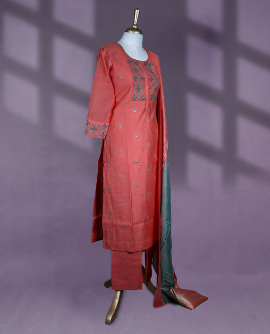 Vibrant rust orange colour salwar set featuring a round neckline, three quarter sleeves, delicate thread embroidery on the yoke and sleeves, with a contrasting dupatta and matching bottom