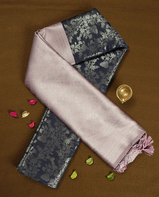 Navy blue colour semi silk saree adorned with subtle silver floral patterns on the body, complemented by contrasted a pastel light pink pallu intricately  woven with rich floral patterns border and pallu, and paired with a matching blouse