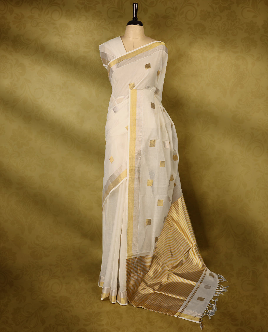 Off white colour pure handloom cotton kerala saree with gold and silver square motifs on the body,  gold and silver zari border, pallu adorned with  gold and silver zari squares motifs, with matching blouse