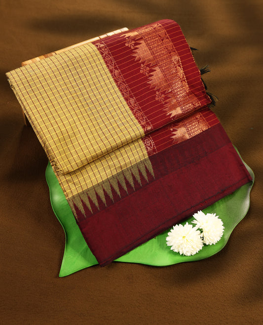 Antique Gold colour mixed Kalyani cotton saree featuring Mustard & Maroon checks throughout the body, paired with a maroon colour traditional border and pallu, with matching blouse