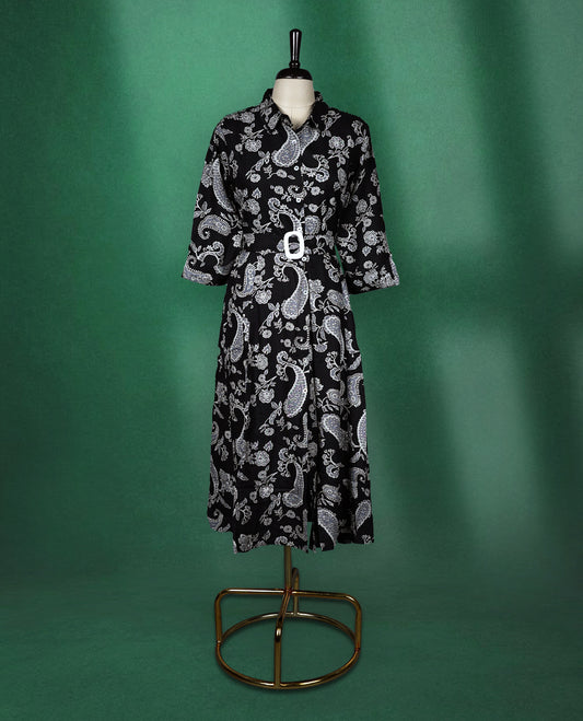 Black shirt style kurti dress featuring elegant white paisley prints, designed with a collared neckline, front buttons, 3/4th sleeves, and a matching fabric belt to accentuate the waist perfect for a smart Indo western look.