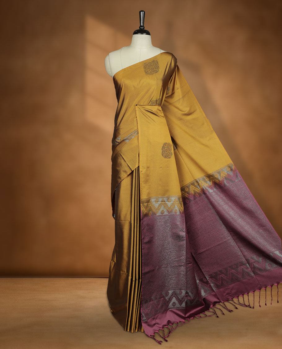Dark mustard colour semi soft silk saree adorned with delicate woven motifs on the body, complemented by a Contrast rouge colour woven pallu with intricate detailing and tassel accents without border & Comes with a matching blouse piece.
