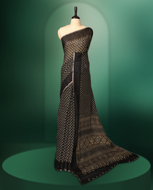 Black colour saree adorned with golden zig zag patterns across the body, complemented by a richly designed traditional pallu, and paired with a matching blouse