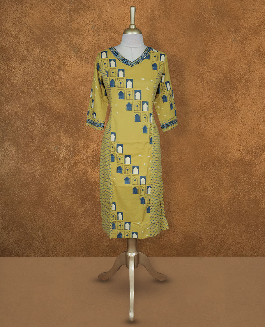 Mustard yellow colour printed kurti by Talisha with V neckline, geometric window motifs in blue and white, straight calf‑length silhouette, and three‑quarter sleeves with contrast printed borders.