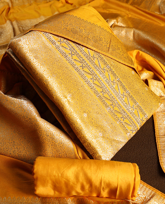 Yellow colour churidhar material with golden zari floral patterns and sparkling stone work, paired with a plain matching bottom and dupatta.