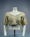 Pastel brocade padded readymade blouse featuring a diamond shaped multicolor weave in soft tones of sage green, peach, and gold, finished with elbow length sleeves and a flattering V neckline