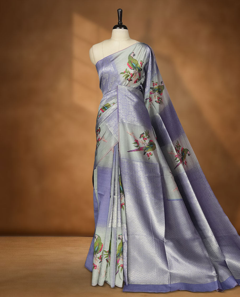 Gray Blue colour semi tussar Banarasi saree featuring printed parrot and floral motifs, gray blue zari border, and a matching blouse with woven accents.
