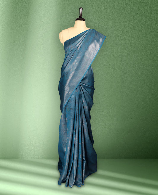 Deep Teal colour semi silk saree featuring neem zari floral kodi motifs all over the body, complemented by a rich self colour woven border, with matching blouse.