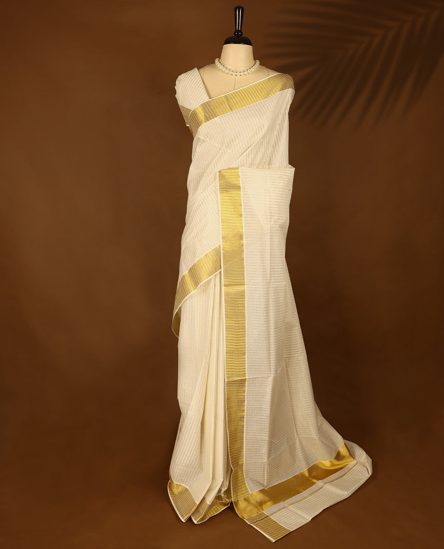Off White Kerala Kasavu saree featuring a broad golden zari border with subtle striped detailing, paired with a matching blouse