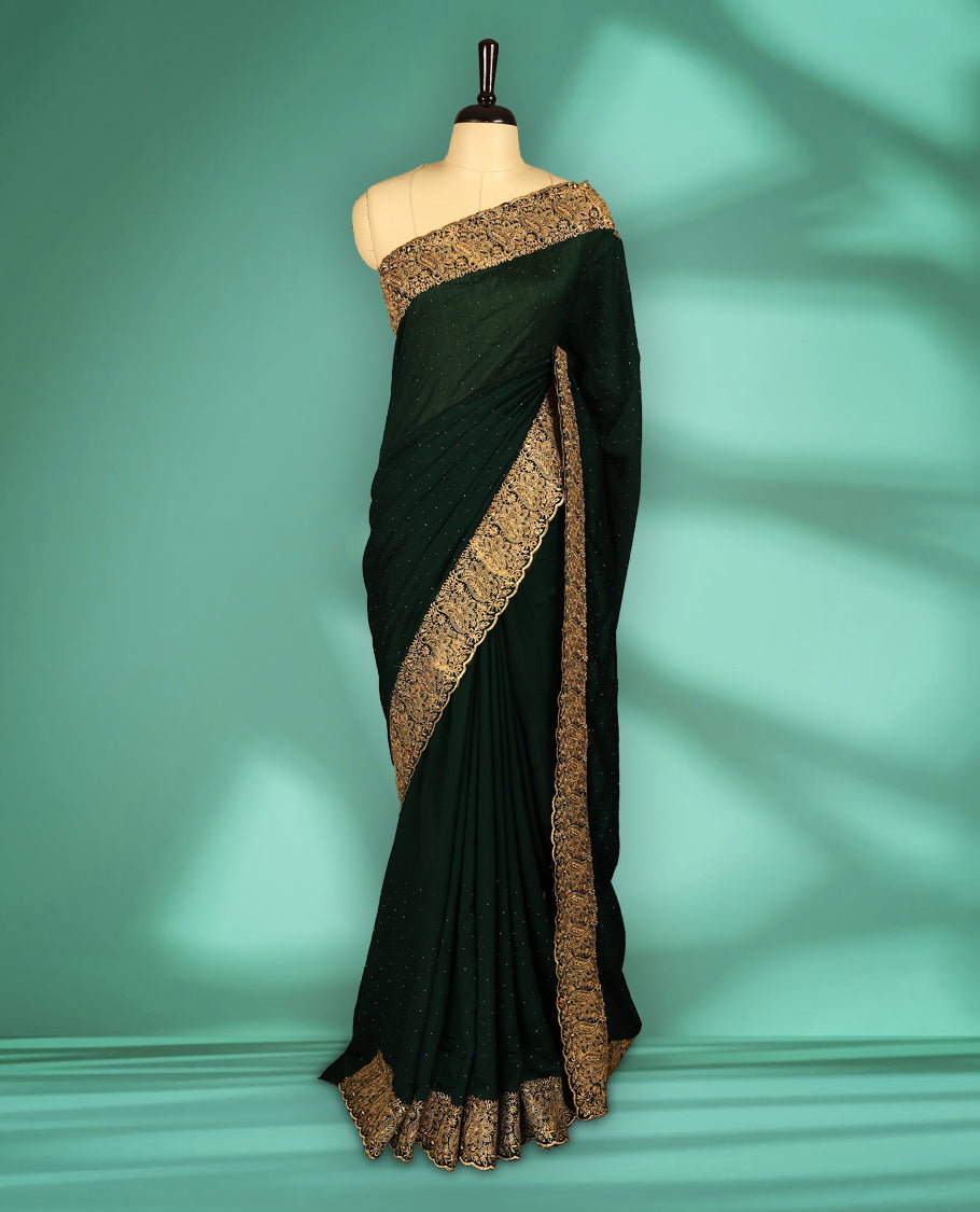 Bottle Green colour Vichitra silk fancy saree featuring tiny stone embellishments across the body, accentuated with a heavy floral embroidery border in gold thread, with matching blouse