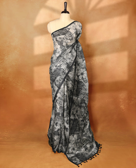 Black colour pure tussar silk light weight saree with full body abstract off white colour floral print, no defined border and pallu, paired with matching abstract printed blouse.
