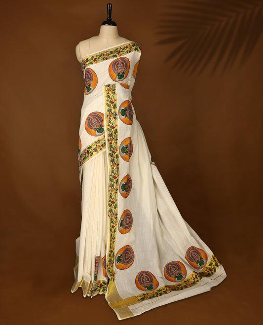 Graceful off white colour cotton Kerala saree featuring vibrant Kathakali face motifs and a floral printed golden border. Traditional yet striking, perfect for festive and cultural celebrations.