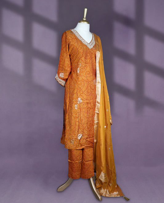 Deep Mustard colour salwar set with V neck and elbow sleeves featuring bandhani inspired dotted pattern with gold motifs paired with matching bottom and dupatta with tassel detail