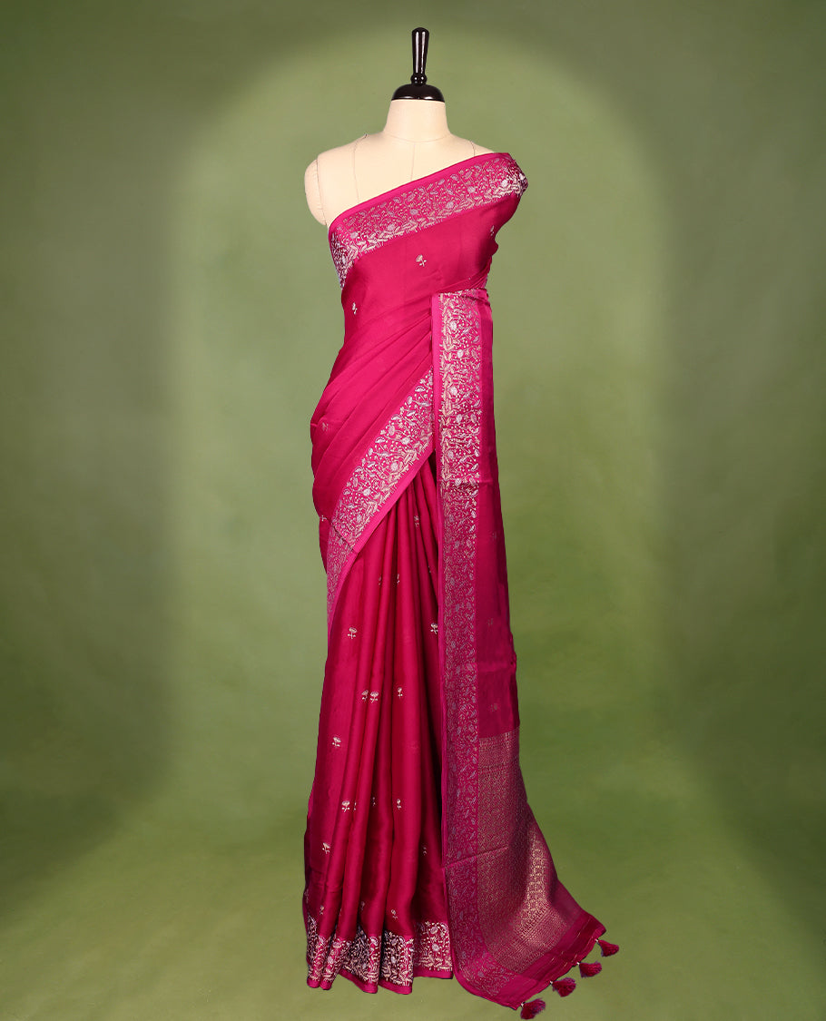 Magenta colour pure Banaras crepe saree showcases elegant Gold zari Flower Motifs all over the body, a traditional gold & Silver zari border, a rich intricately woven pallu, and comes with a matching blouse.