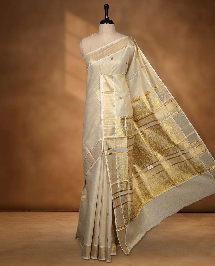 Elegant light gold tissue Kerala saree featuring delicate tree-inspired gold zari buttas across the body. Finished with a broad traditional kasavu border and a richly woven pallu, paired with a matching blouse