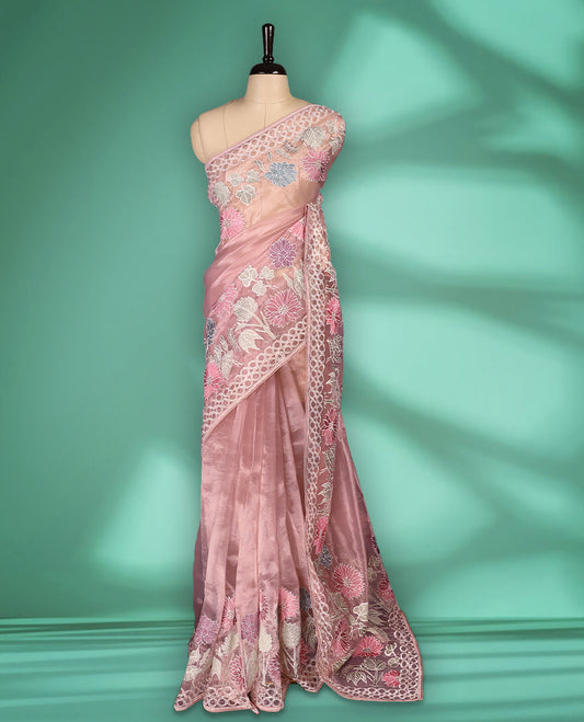 Lignt Pink colour organza designer saree featuring delicate pastel floral embroidery in pink, mint green, and white across the body, with a scalloped border accentuated by floral threadwork, and a gracefully embroidered pallu paired with matching blouse.