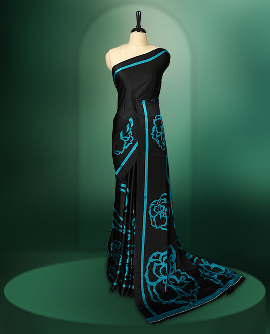 Black colour saree adorned with bold Light Blue floral motifs and matching border accents, paired with a coordinating blouse