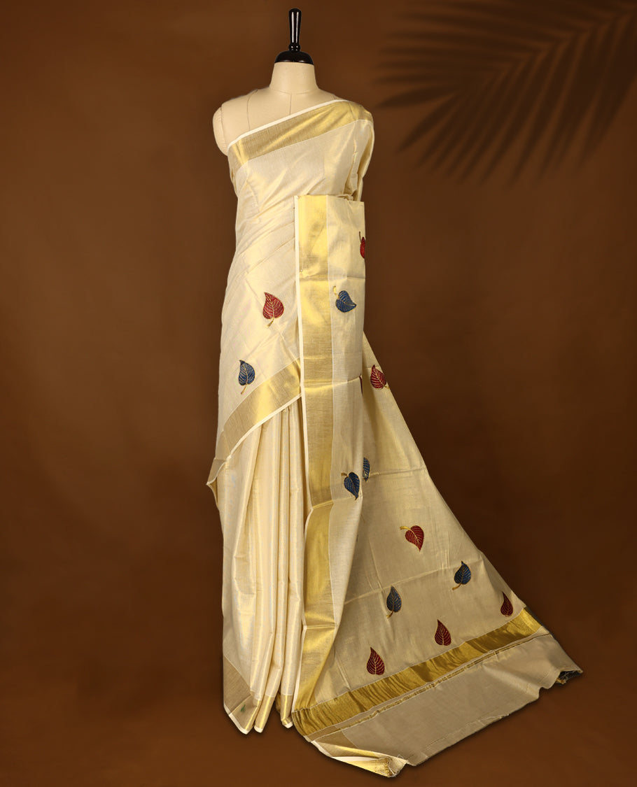 Light Gold colour Tissue Kerala saree featuring leaves Embroidery body and a beautifully woven Gold Kasavu border,  paired with a matching blouse perfect for festive occasions.