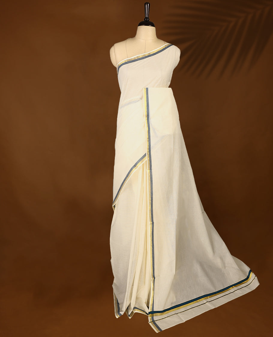 Elegant off white colour cotton Kerala saree featuring a plain body and traditional golden zari border with a hint of Midnight Blue, offering a classic and graceful look, paired with a matching blouse.