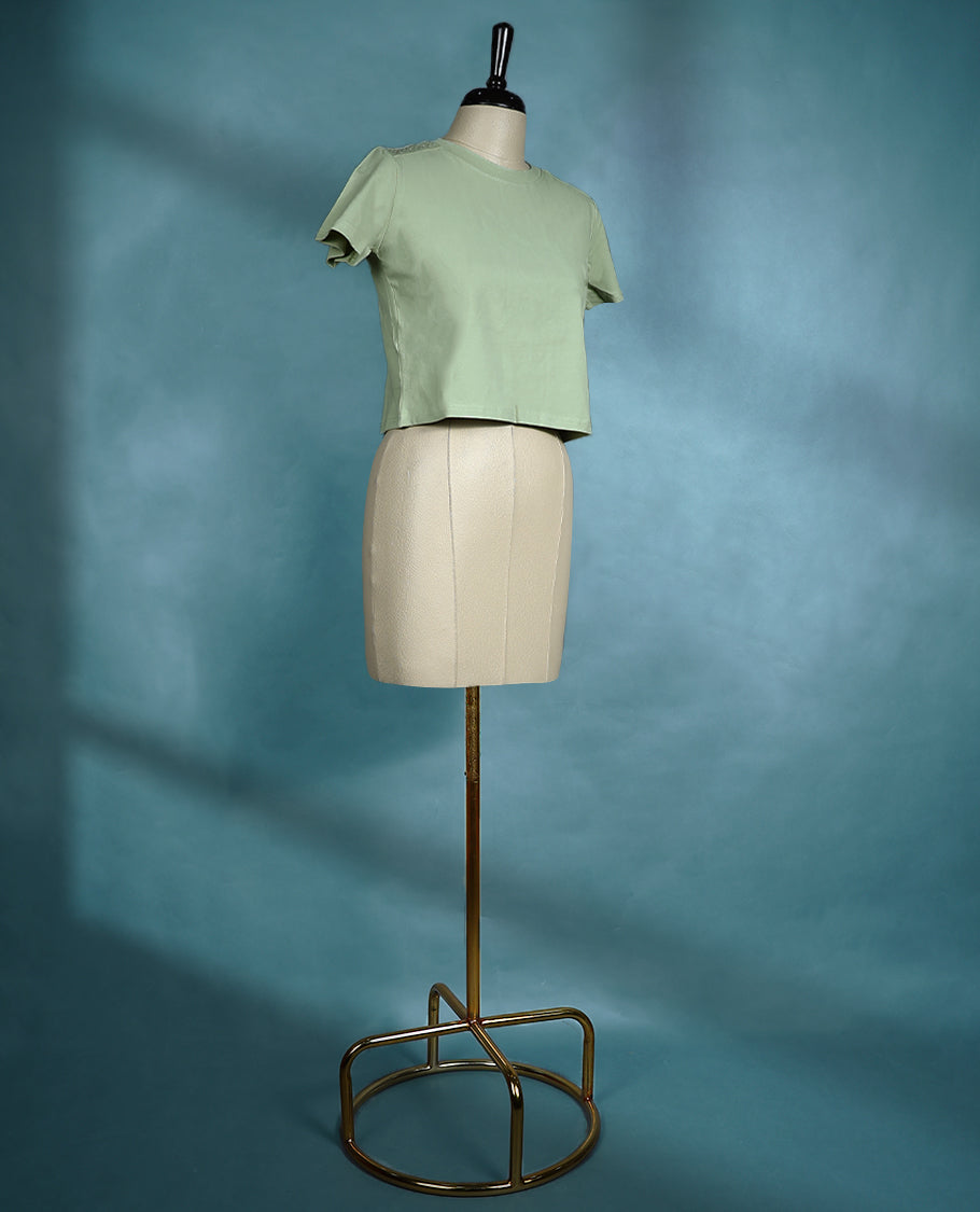 Pastel Green short sleeve T shirt with a round neck, featuring subtle stud detailing on the shoulders for a sleek, edgy twist on everyday comfort.