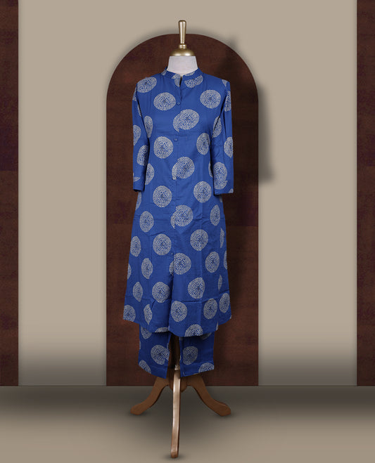 Brick blue colour cotton cord set featuring a straight kurta with a mandarin collar, front buttons, and three quarter sleeves & adorned with white circular block prints and paired with matching palazzo pants.